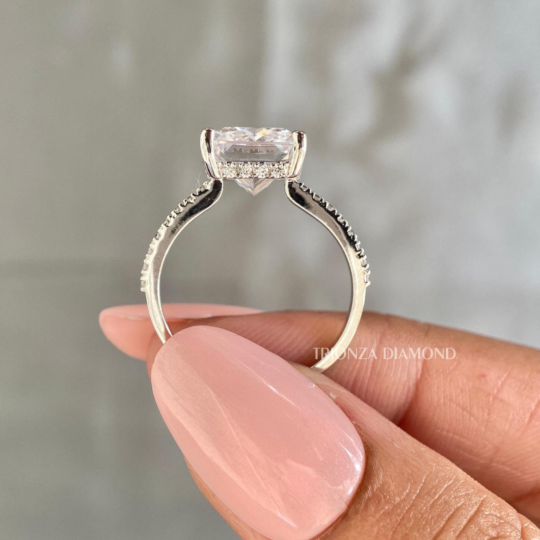 Radiant cut lab grown diamond engagement ring featuring a pave set band and round side stones