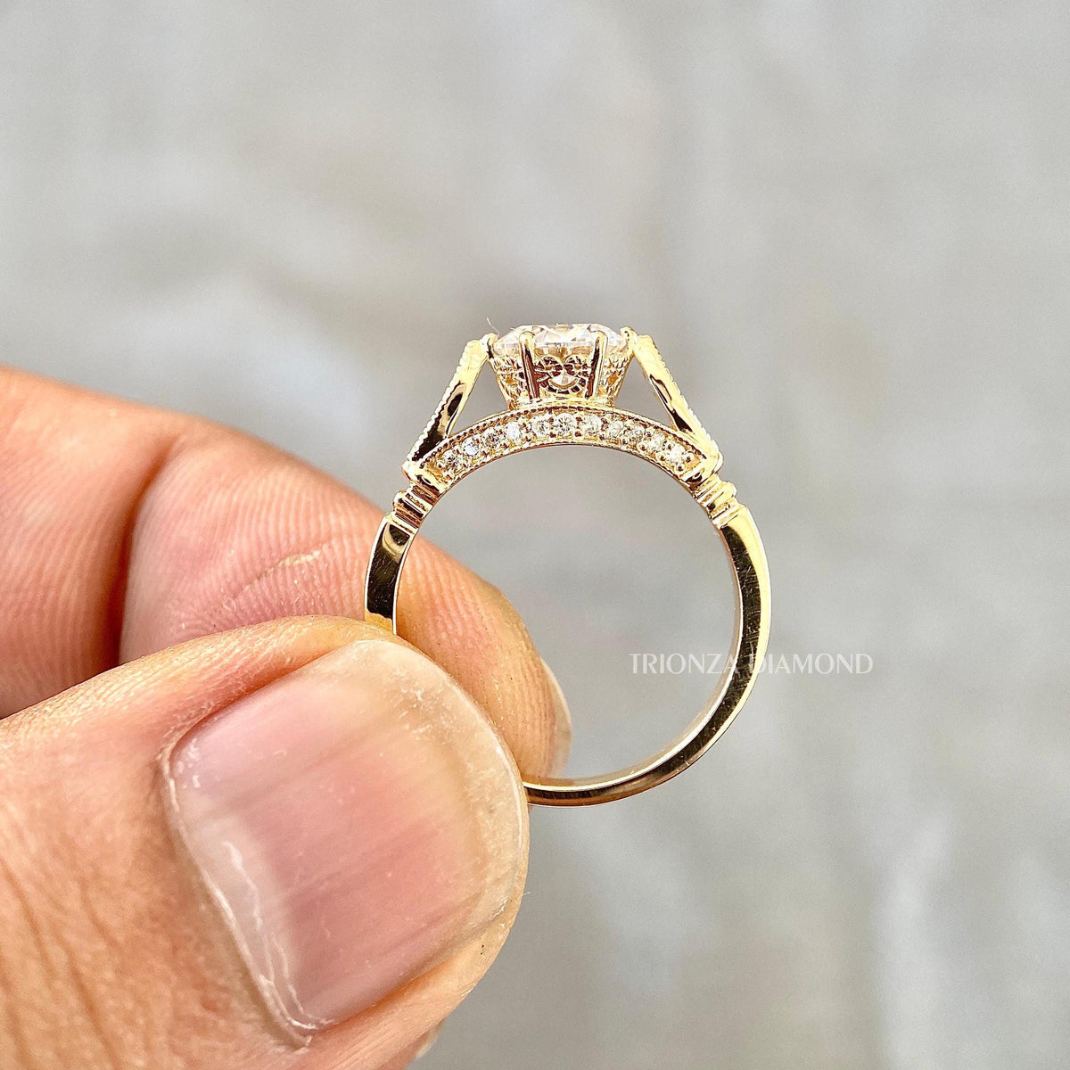Close-up of the 1 CT round cut center diamond set in a floral gold ring design