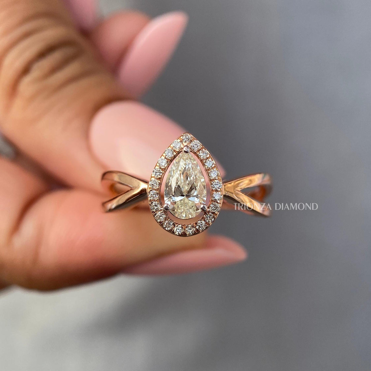 Pear cut diamond ring shown alongside its jewelry box and smooth fabric packaging