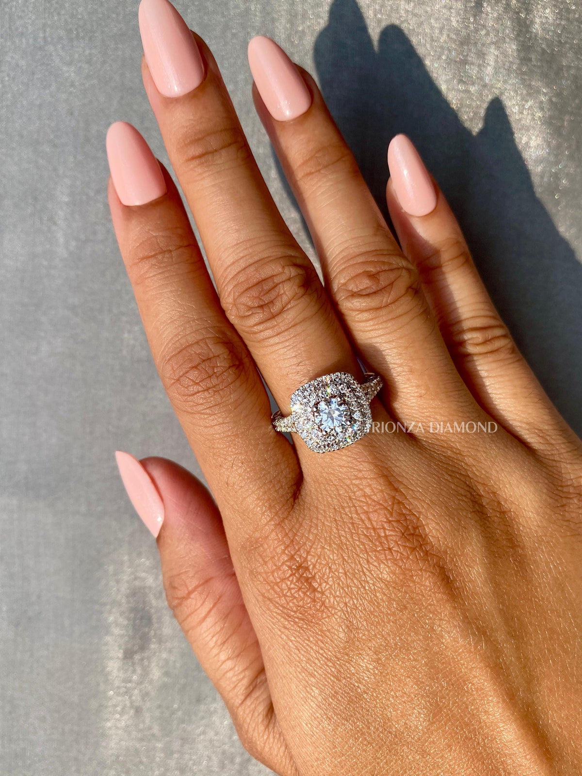 Woman wearing the round diamond halo ring, close-up view on her hand