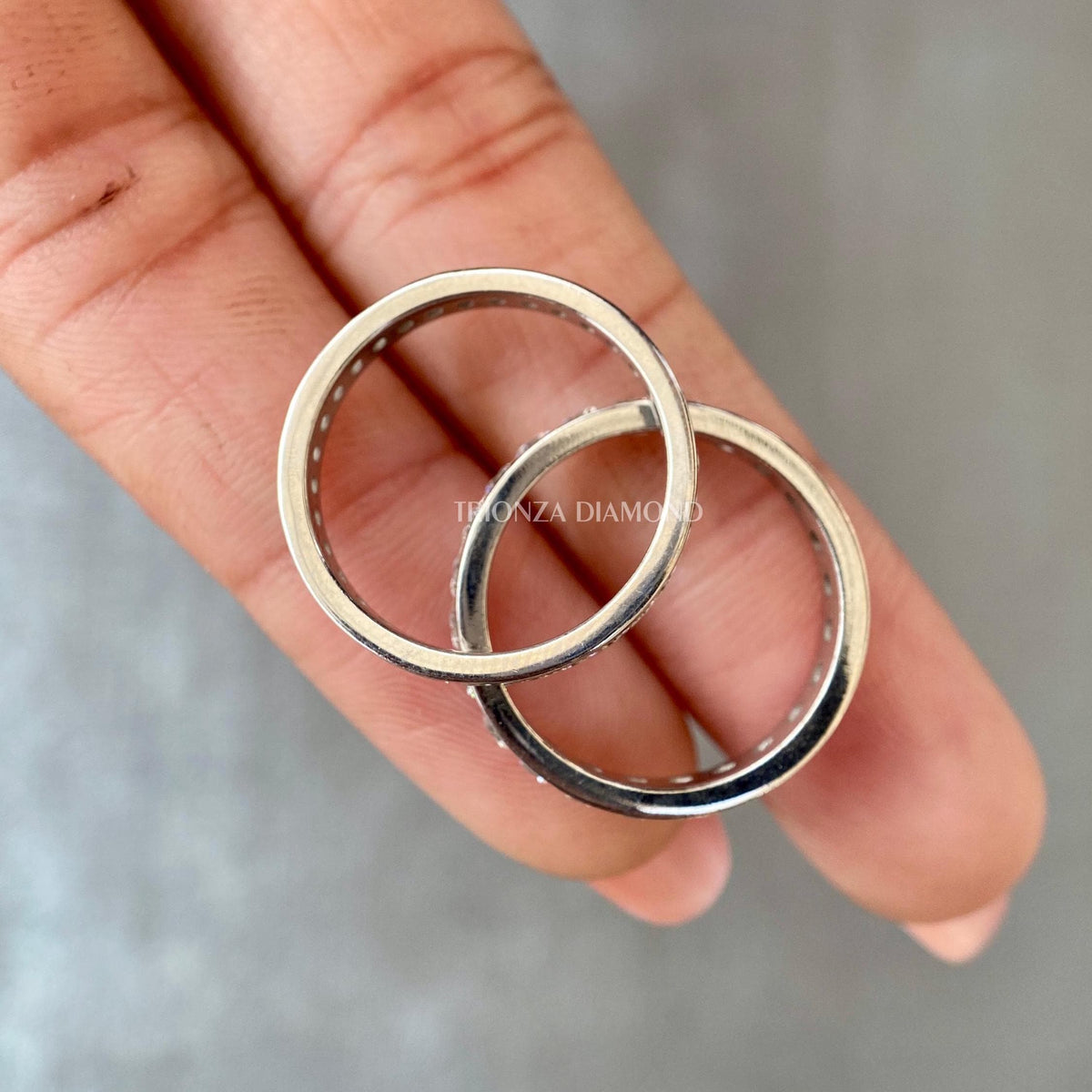 Woman wearing the round diamond stackable band styled with other wedding rings