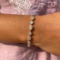Fancy yellow lab grown diamond tennis bracelet featuring pear, oval, and round cut stones in 14K gold