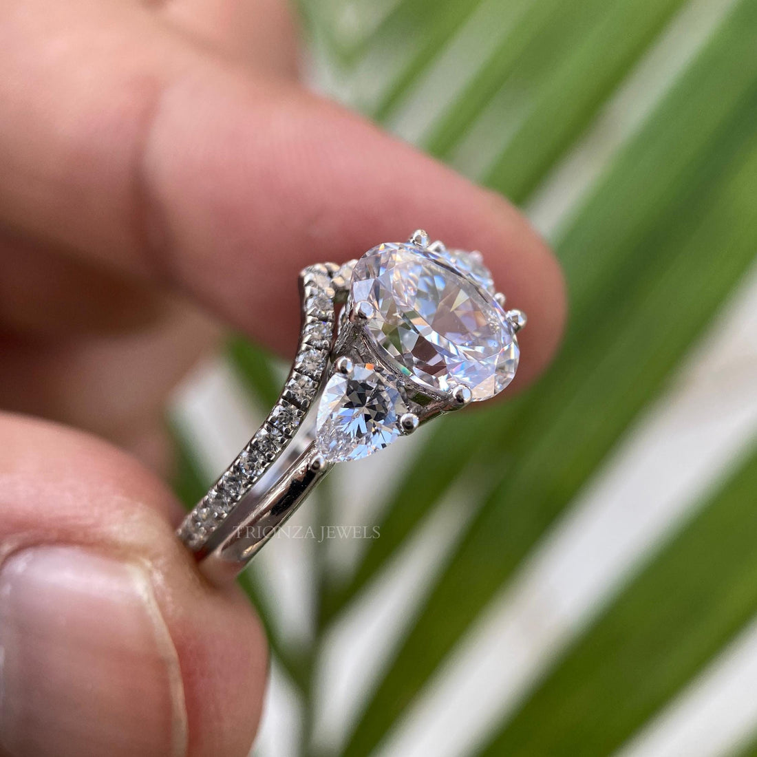 Oval cut moissanite bridal set ring featuring pear cut side stones in 14k gold