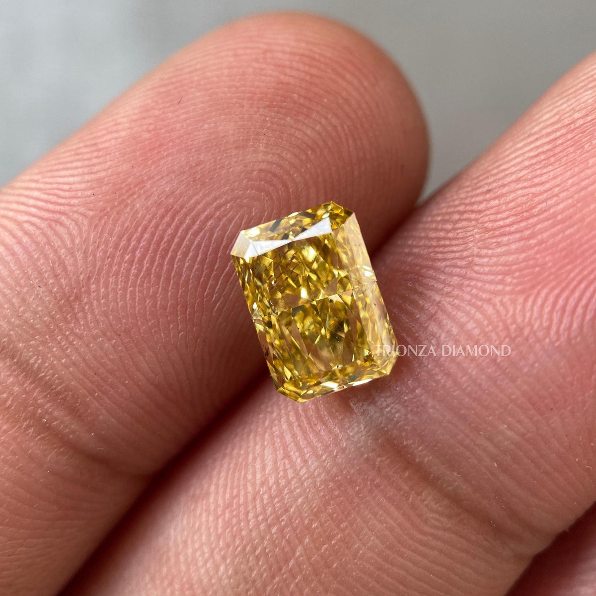 Radiant cut yellow diamond displayed to highlight its Fancy Vivid Yellow color and VS2 clarity