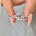 Oval lab grown diamond engagement ring featuring pear cut side stones in a three stone design