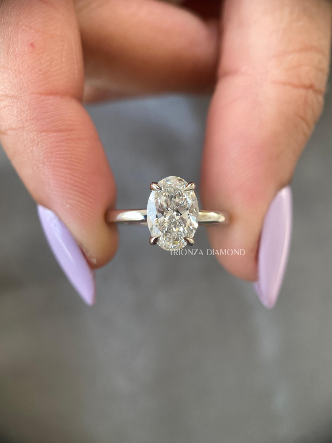 Oval cut lab grown diamond engagement ring featuring a D color VVS2 clarity solitaire stone