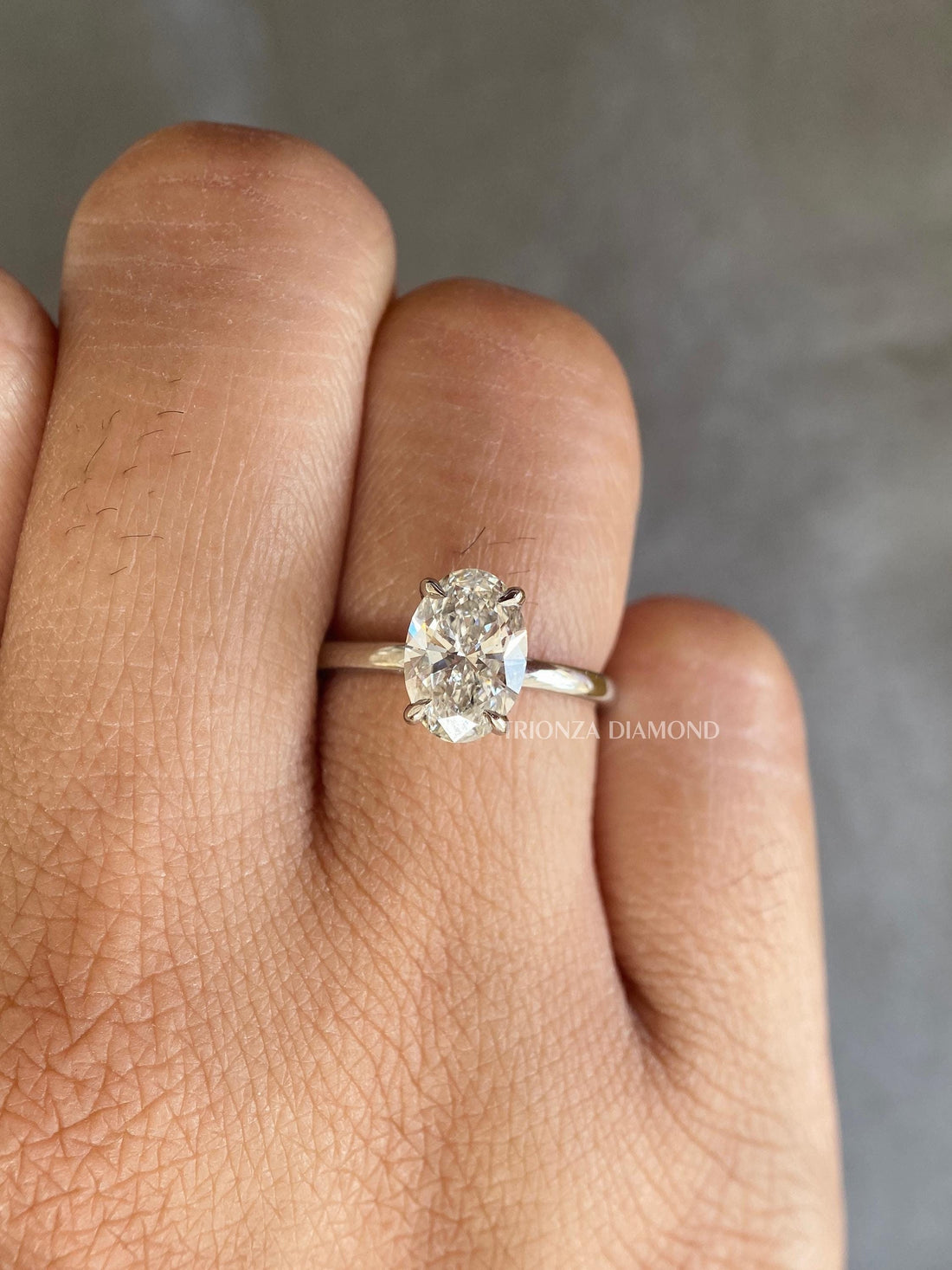Oval cut lab grown diamond engagement ring featuring a D color VVS2 clarity solitaire stone