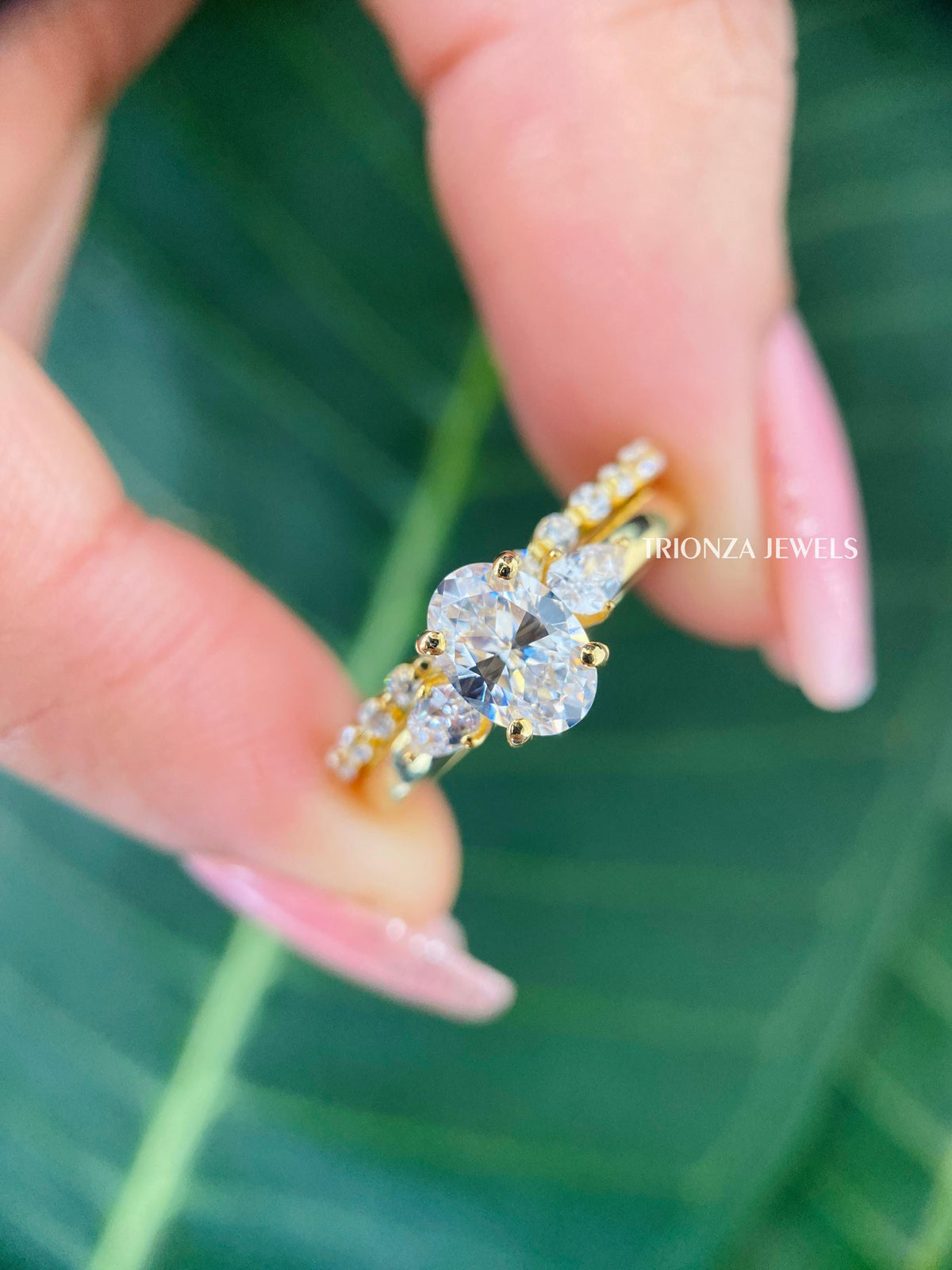 TrionzaDiamond three stone bridal set showcasing the prong set oval and pear cut moissanite stones
