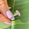Art deco inspired solitaire ring featuring a bezel set emerald cut moissanite center stone