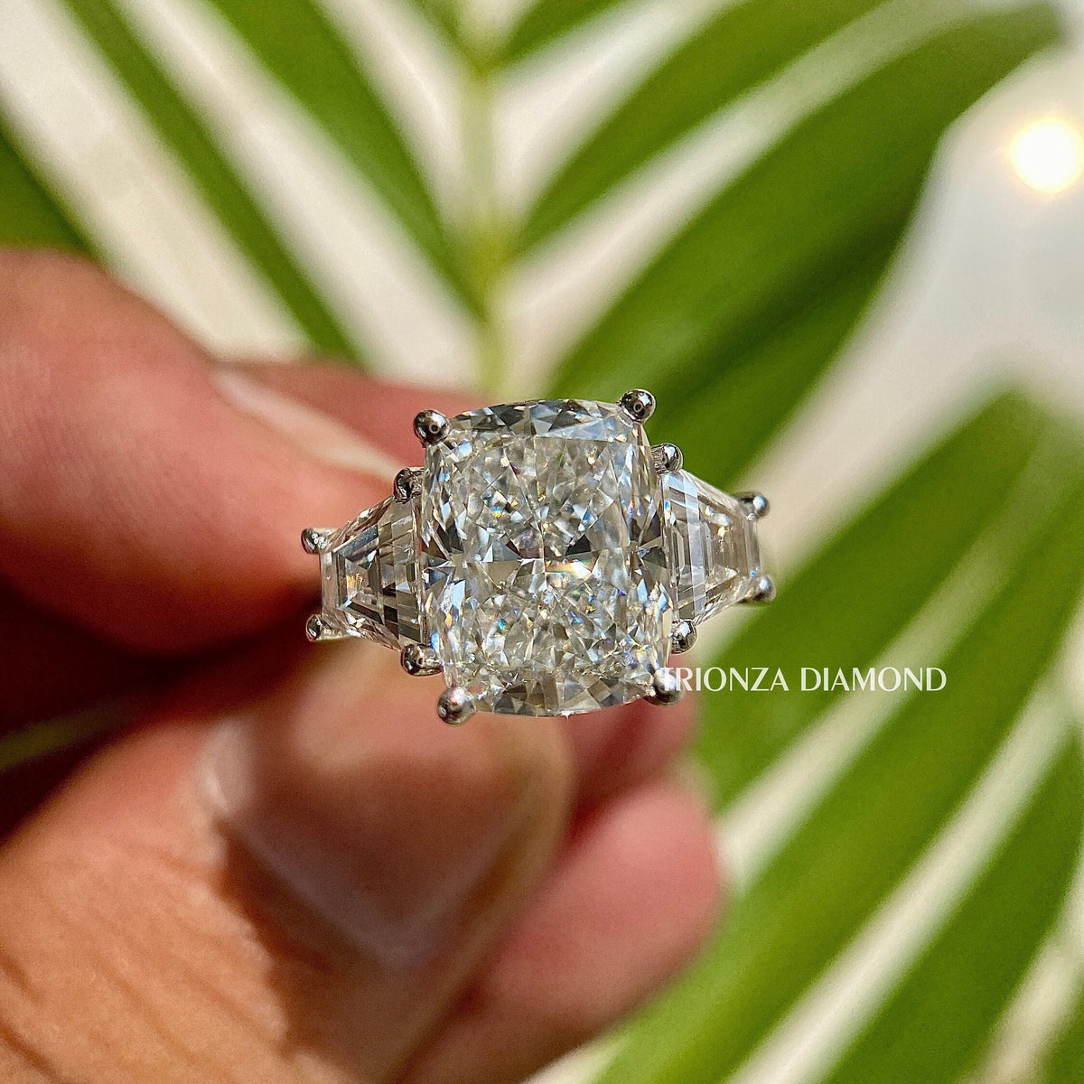 Two tone cushion cut lab grown diamond engagement ring featuring side trapezoid stones