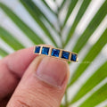 French cut cyan blue moissanite wedding band displayed in a jewelry box with milgrain detail