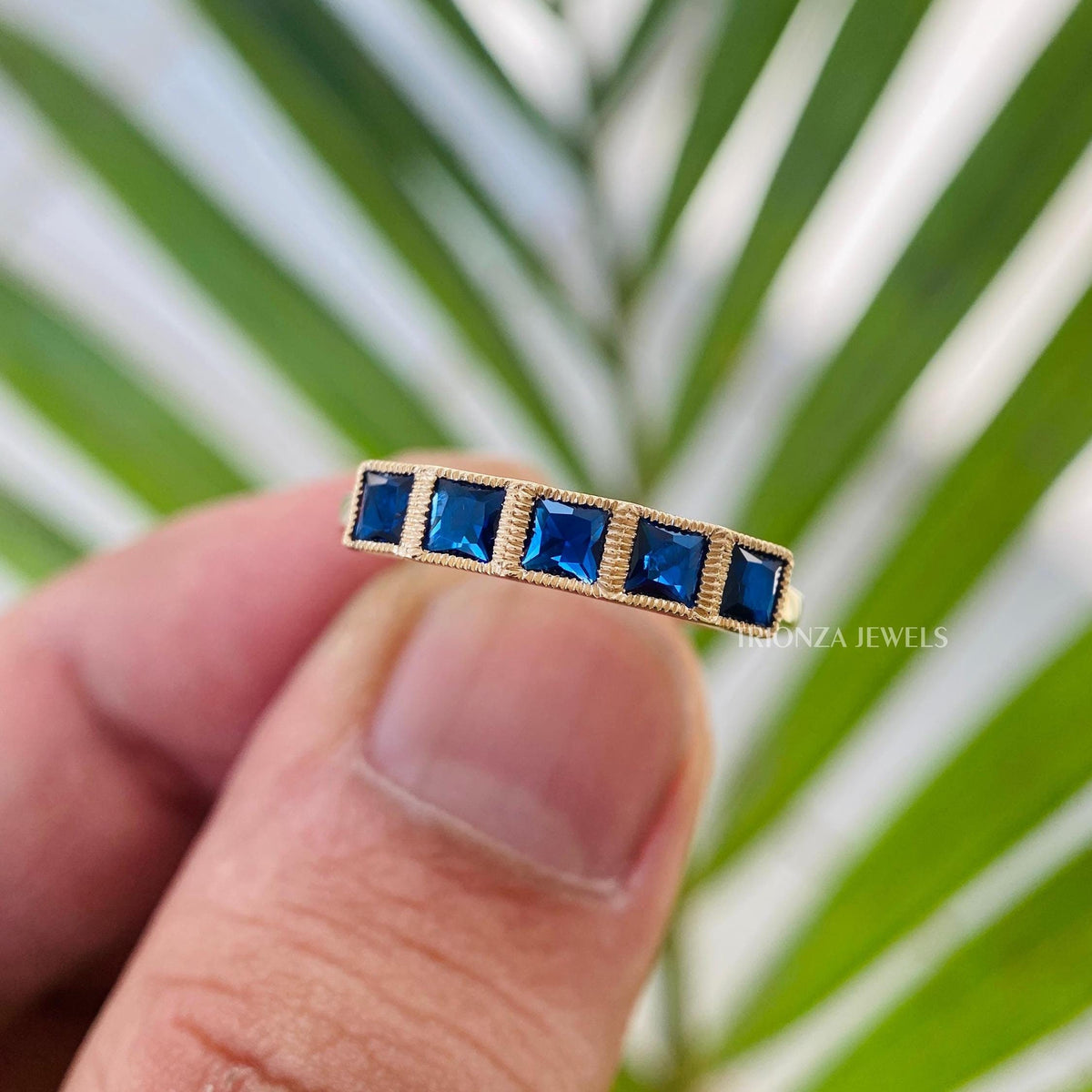 French cut cyan blue moissanite wedding band displayed in a jewelry box with milgrain detail