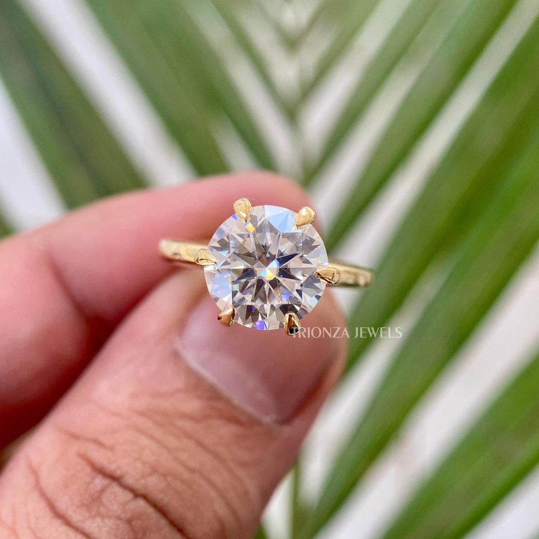 Round cut moissanite engagement ring featuring a 6 prong solitaire setting in solid gold