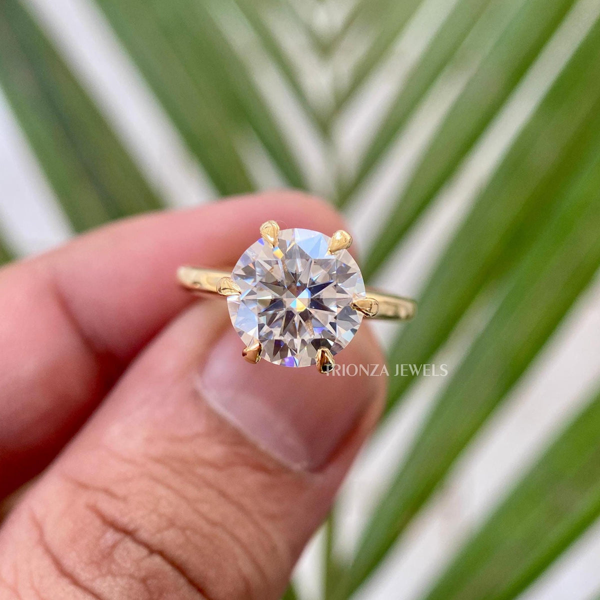 Round cut moissanite engagement ring featuring a 6 prong solitaire setting in solid gold