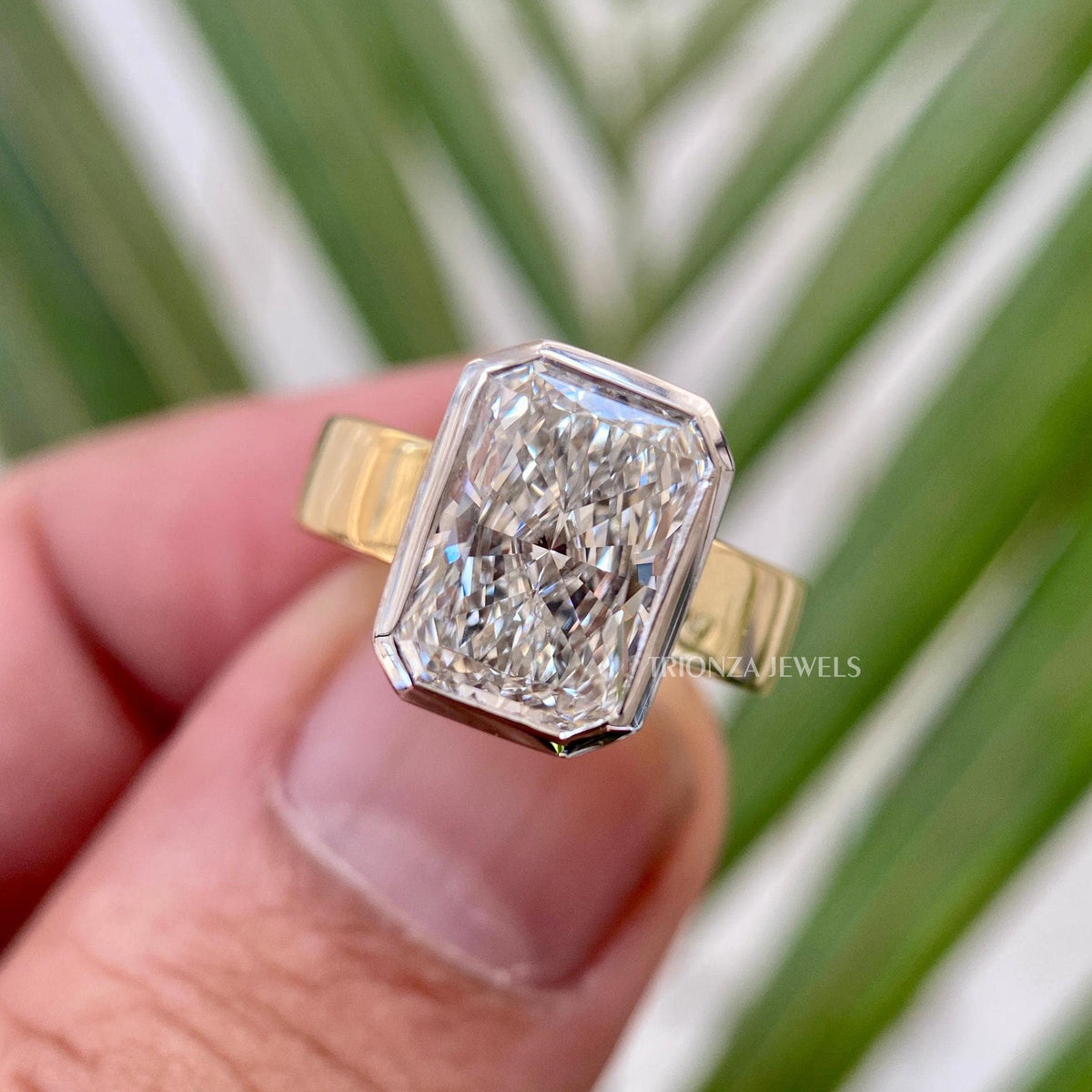 Radiant cut moissanite solitaire engagement ring in 14K two tone gold with bezel setting
