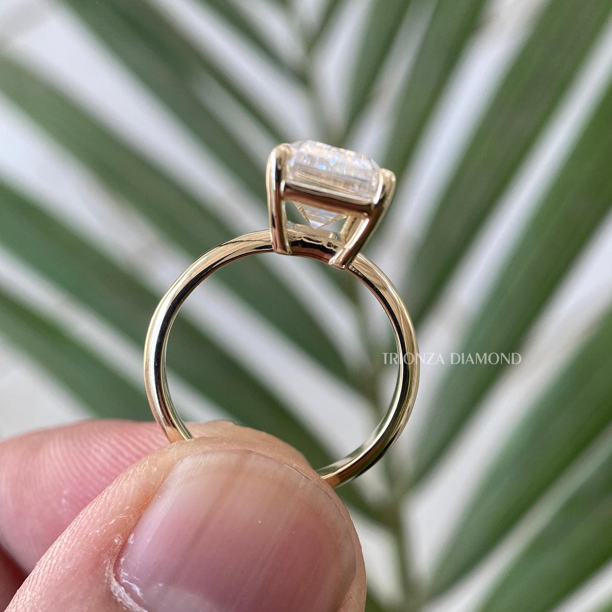 Woman wearing the emerald cut moissanite engagement ring for an elegant everyday look