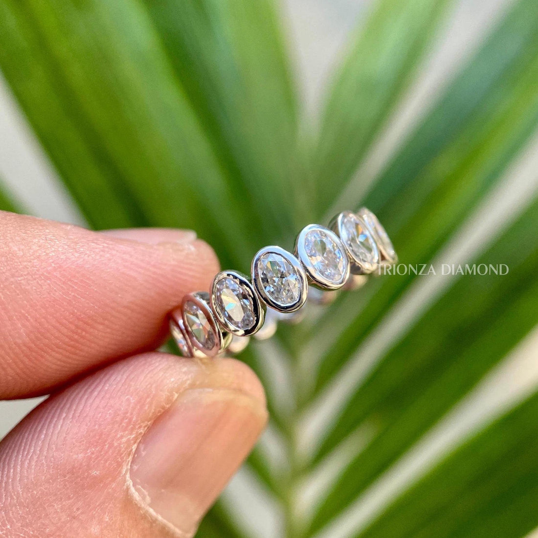 Oval moissanite full eternity wedding band showcasing bezel set stones in 14K gold