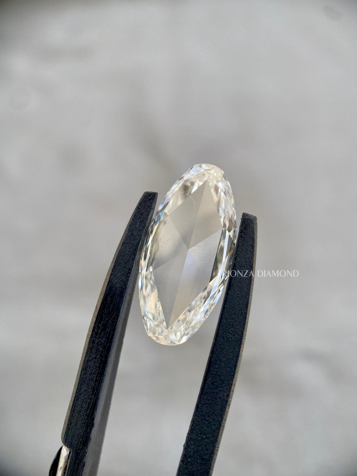 Vintage style rose cut diamond photographed to show its measurement and elongated oval shape