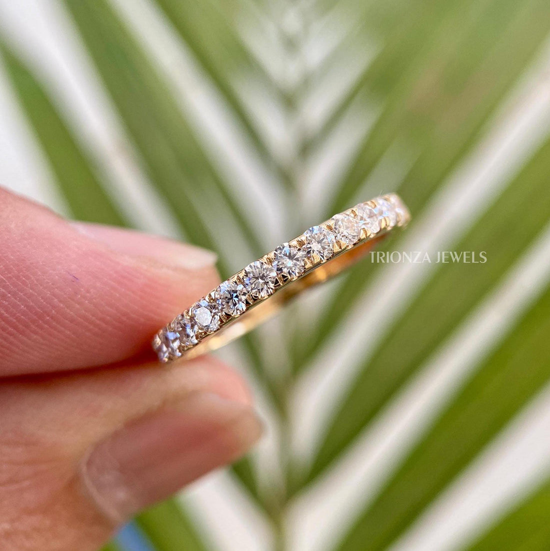 Micro pave moissanite wedding band featuring round cut colorless stones set in a half eternity design