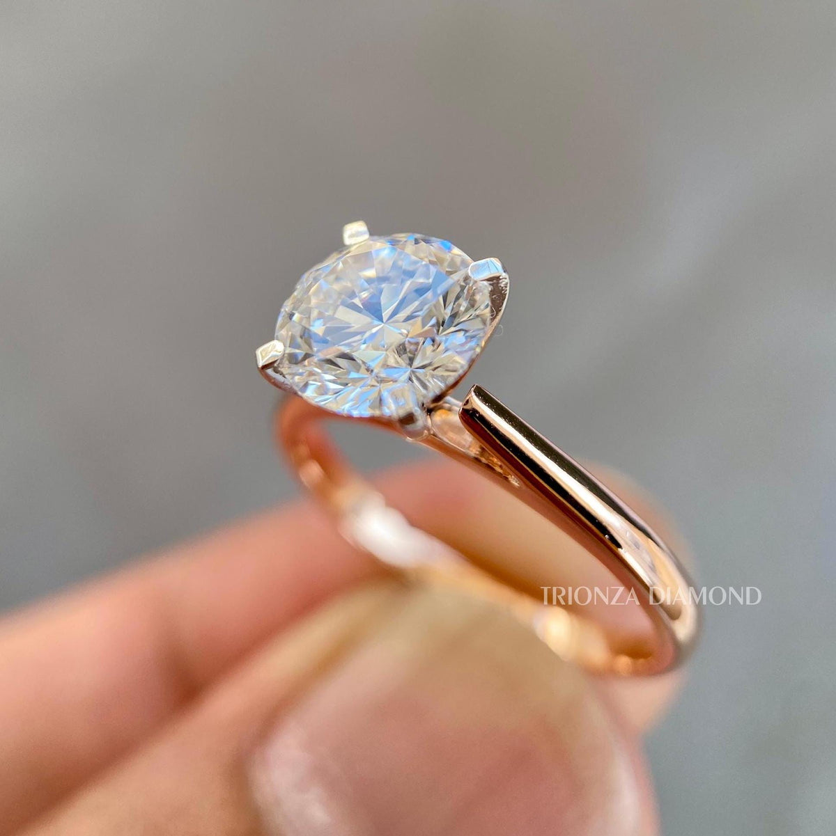 Side view of the solitaire ring showing the 14K yellow gold band and prong details