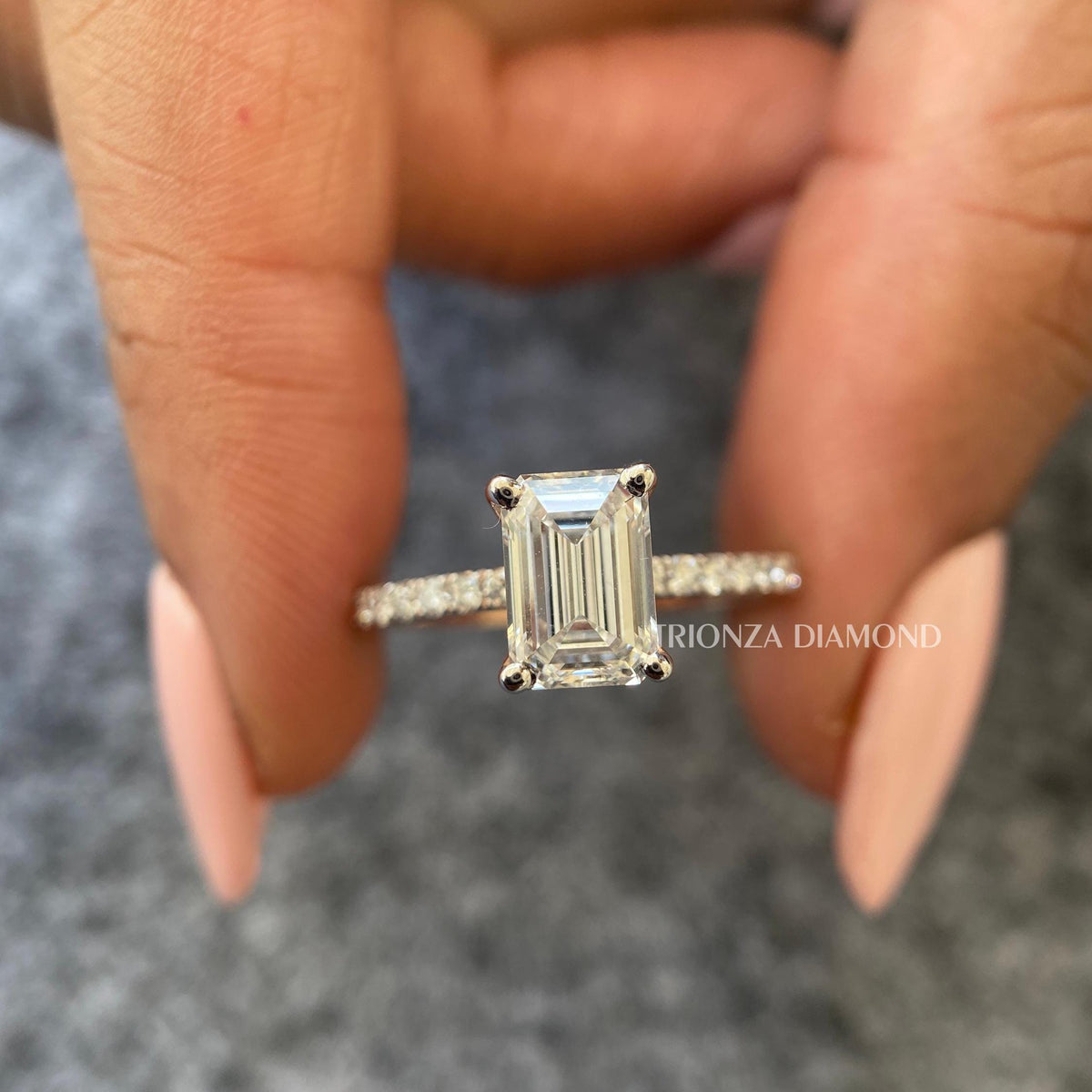Emerald cut lab diamond ring featuring a 1.5 CT stone set in an 18K gold pave band