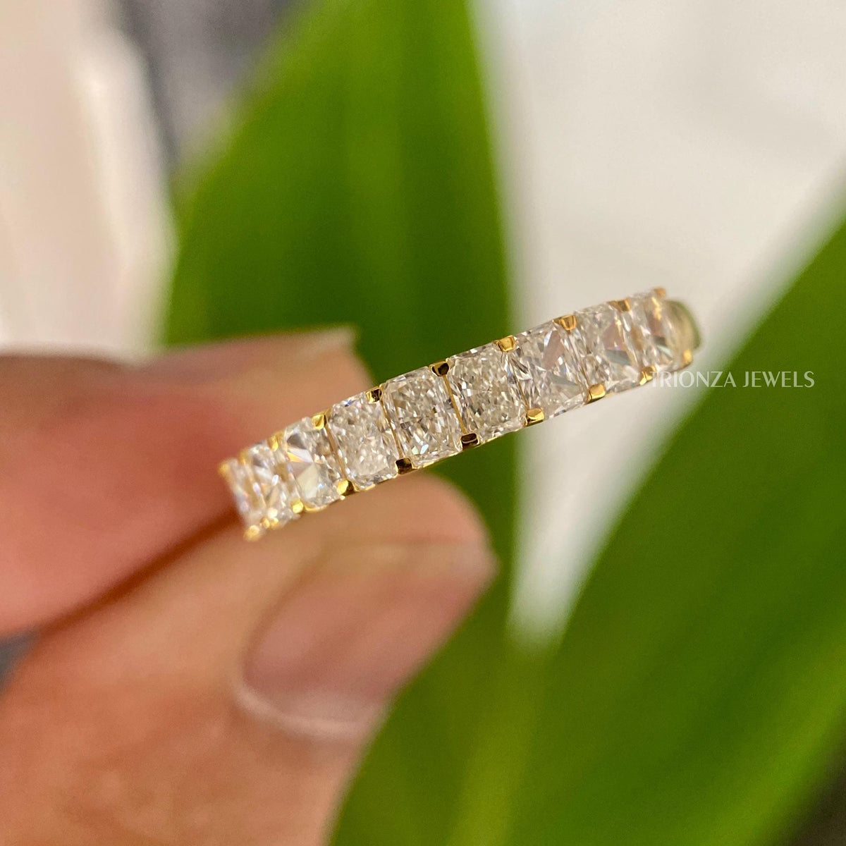 Radiant cut moissanite eternity band showcasing colorless VVS1 stones set in gold