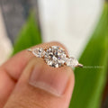 Three stone round moissanite engagement ring with pear cut side stones in a double prong setting