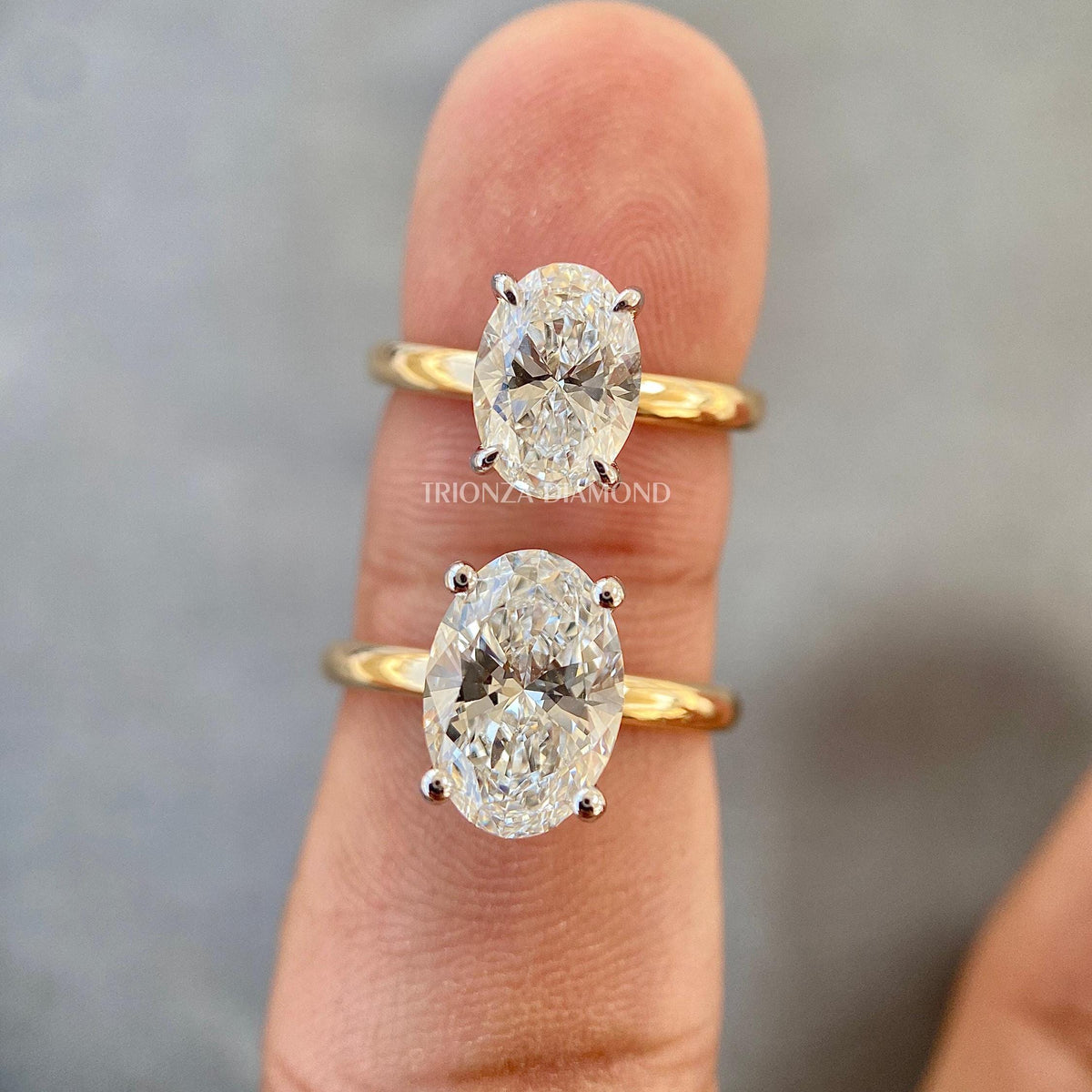 Oval solitaire lab grown diamond ring set in a cathedral style 14K gold band