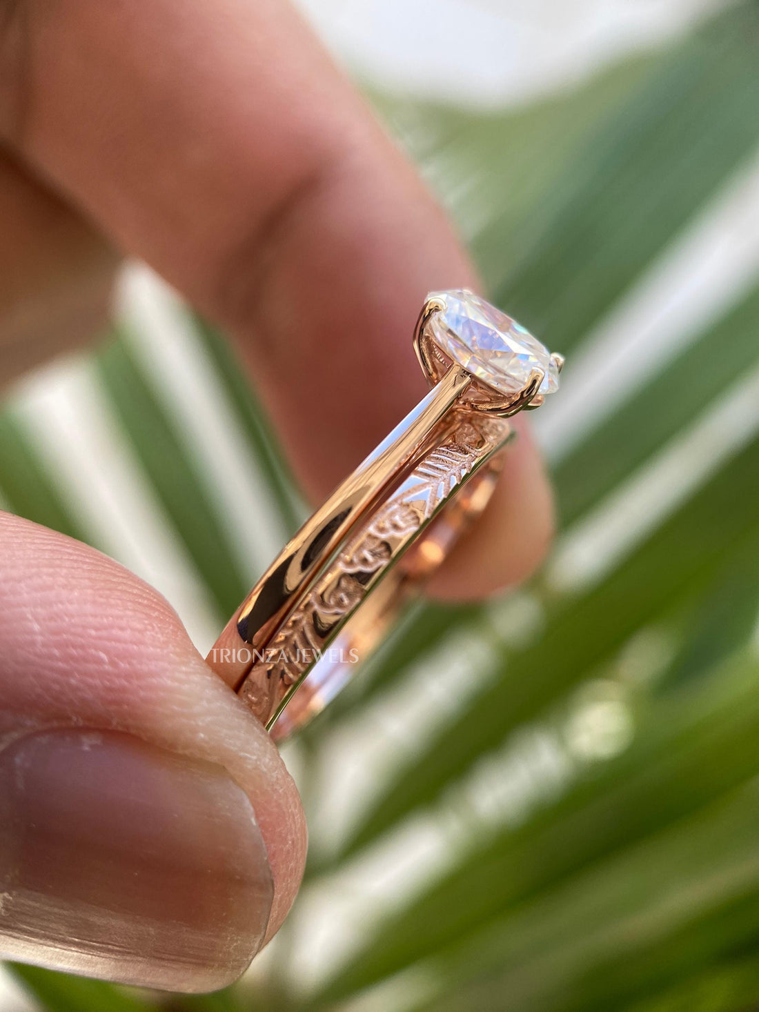 Oval moissanite engagement ring paired with a plain gold wedding band forming a bridal set