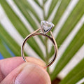 Close-up of the 4 prong setting securing the round moissanite center stone