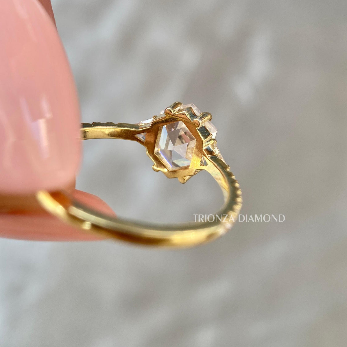 Side view of the ring showing the triangle cut and round cut accent diamonds