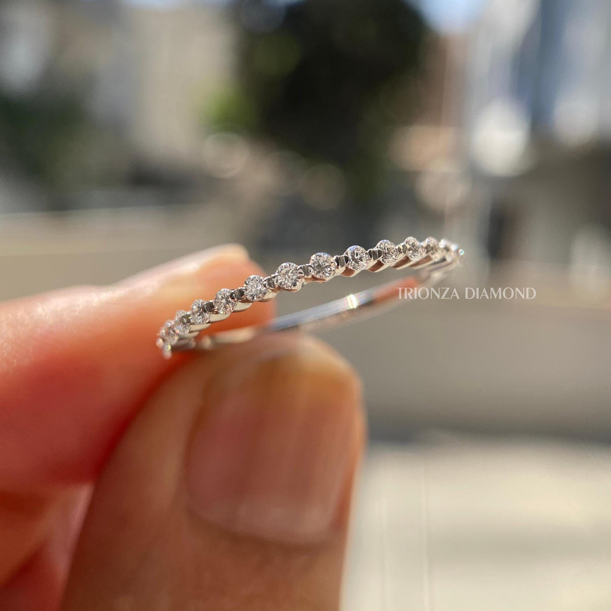 Floating bubble half eternity wedding band featuring a round cut lab grown diamond in single prong setting