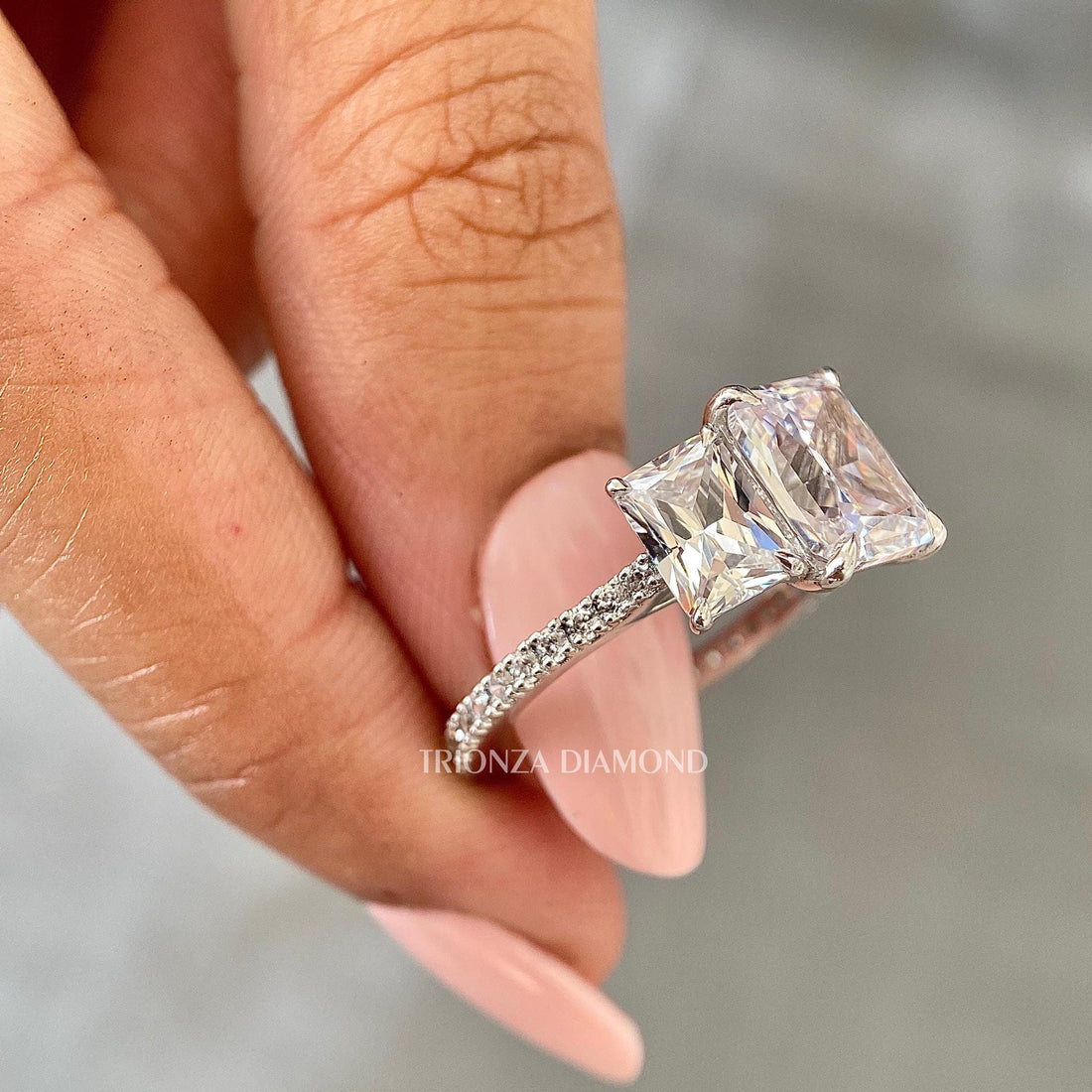 Radiant cut lab grown diamond ring with three stone design and pavé band in 18k white gold