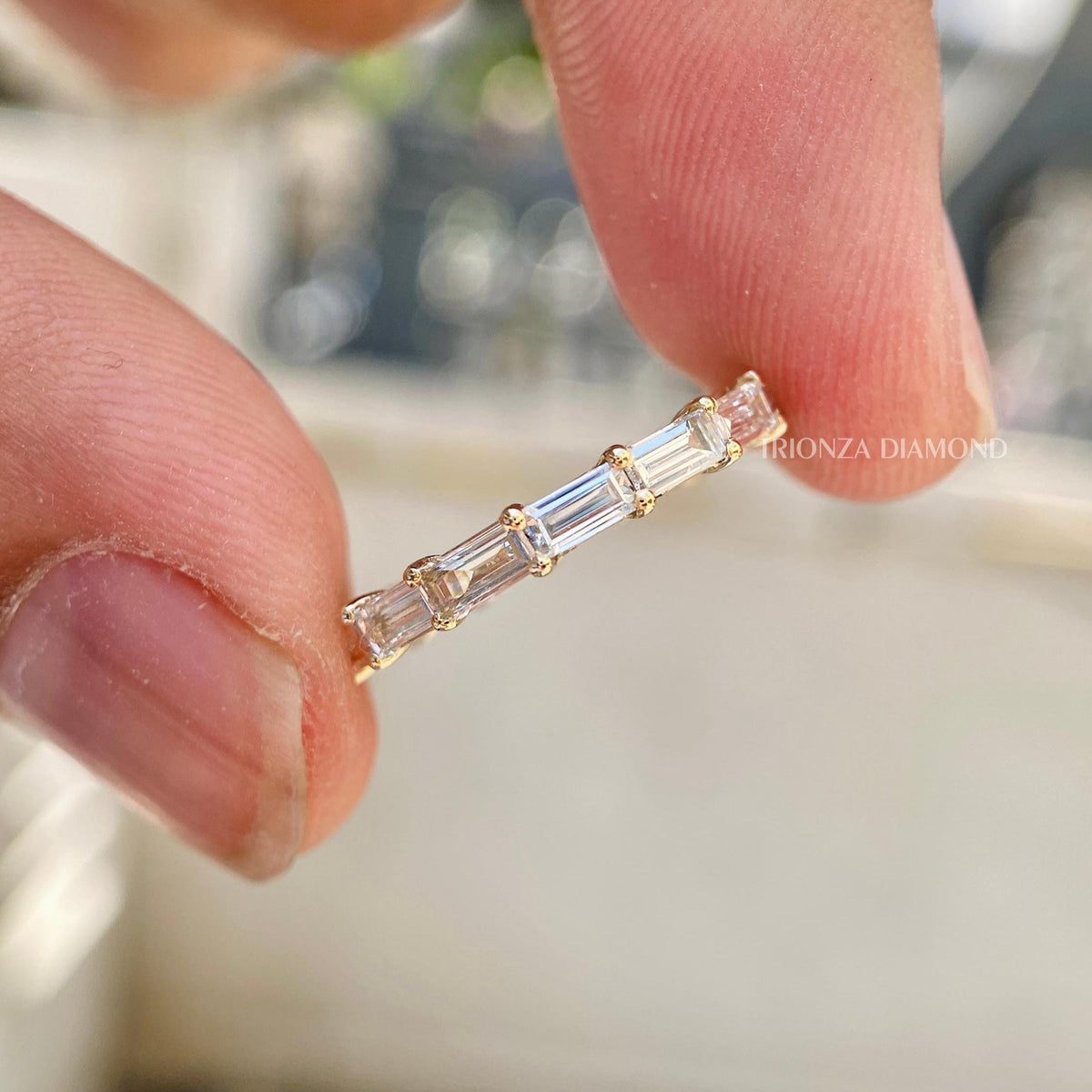 Stackable baguette diamond band shown alongside a matching ring for a layered look