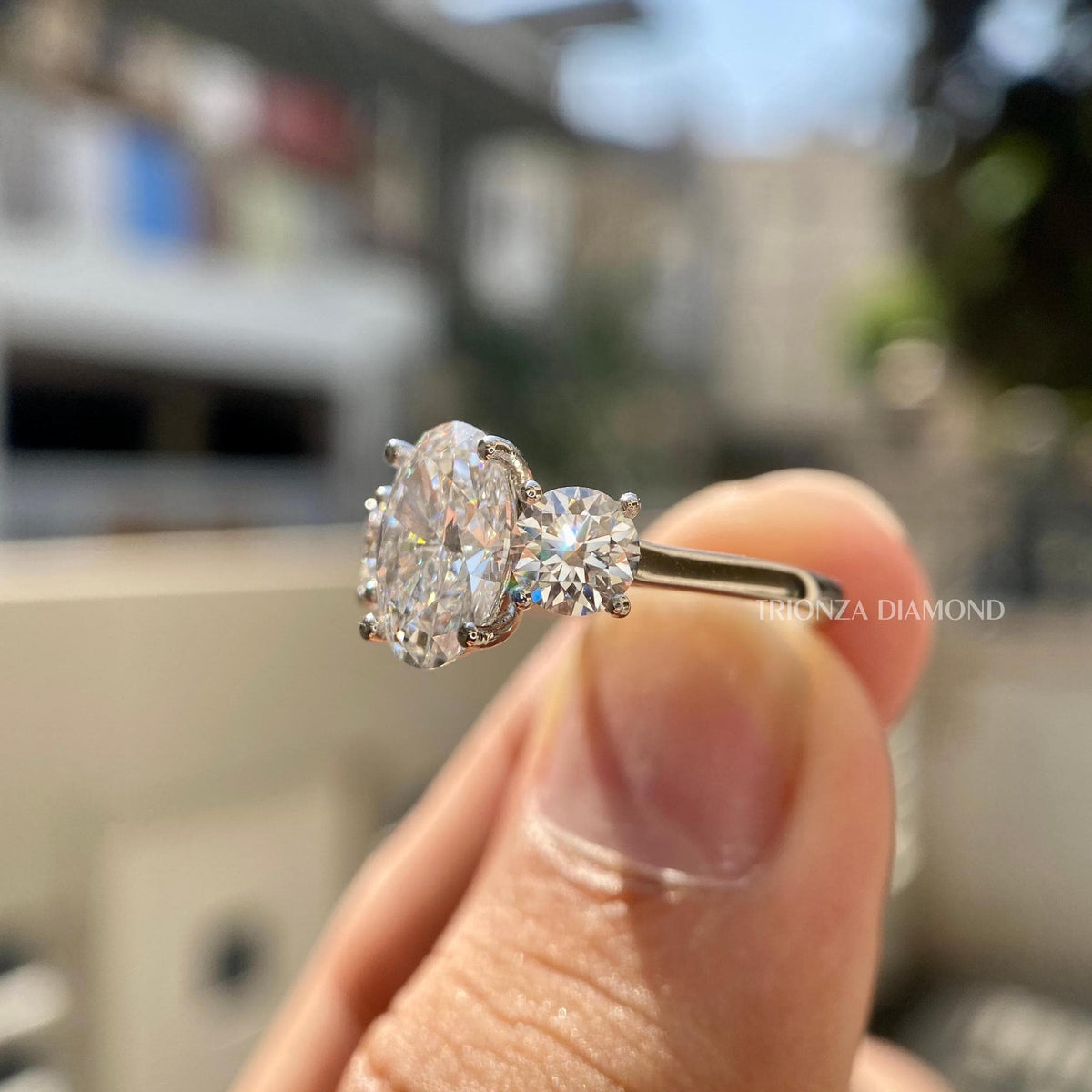 Woman wearing the oval diamond engagement ring, showcasing the three stone setting on her hand