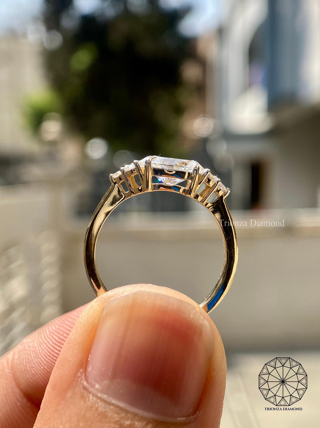 Oval east-west lab grown diamond ring with three-stone accent setting in 14k yellow gold