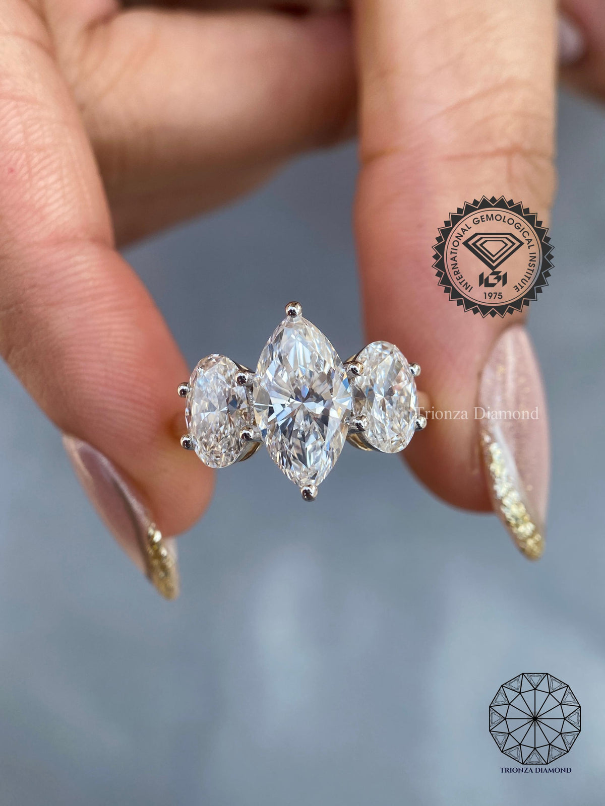 Marquise and oval lab grown diamond three stone ring displayed to show its total 5.5 CT design