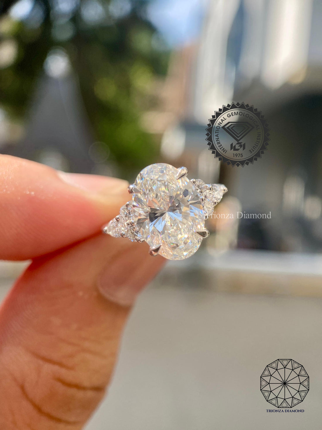 Elongated oval lab grown diamond anniversary ring with round and pear cut side stones