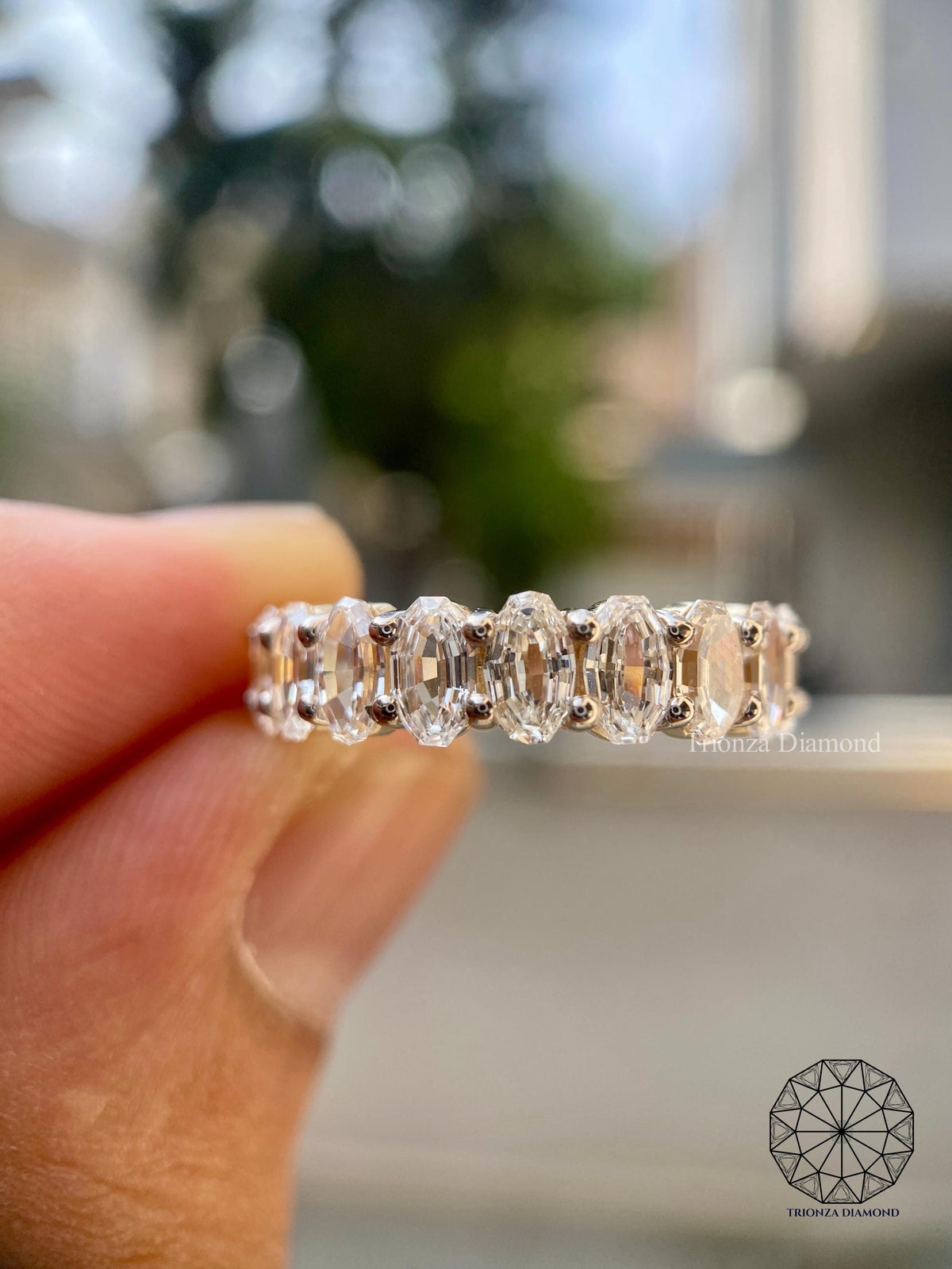 Stackable oval wedding band shown alongside a matching engagement ring