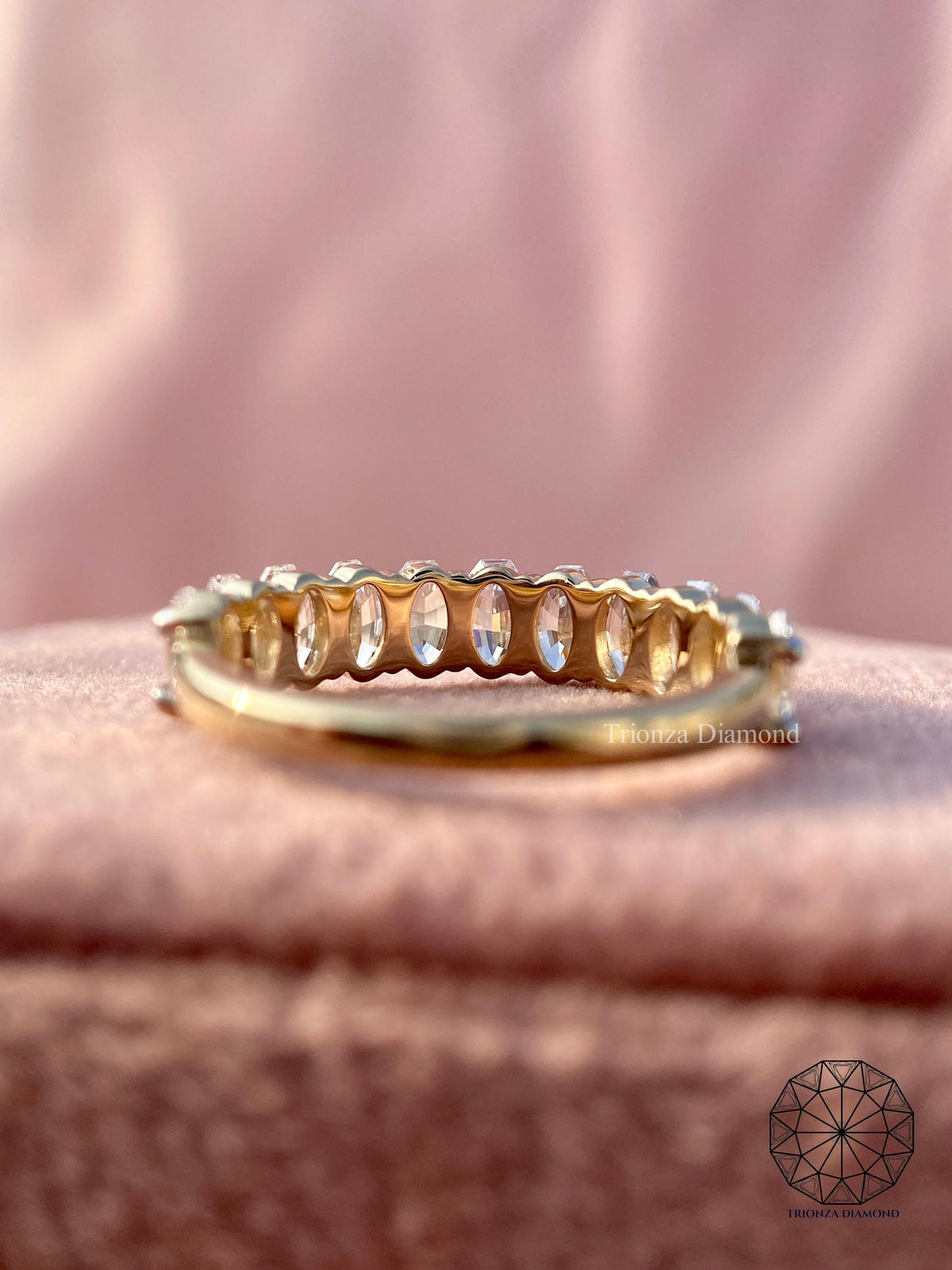 Woman wearing the oval step cut diamond band stacked with other rings