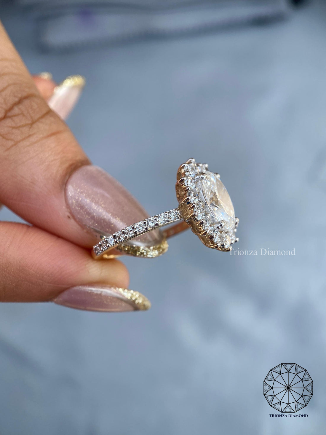 Oval lab grown diamond engagement ring featuring a starburst halo with round accent diamonds