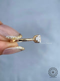Round accent diamonds framing the oval center stone in a graceful brilliant setting