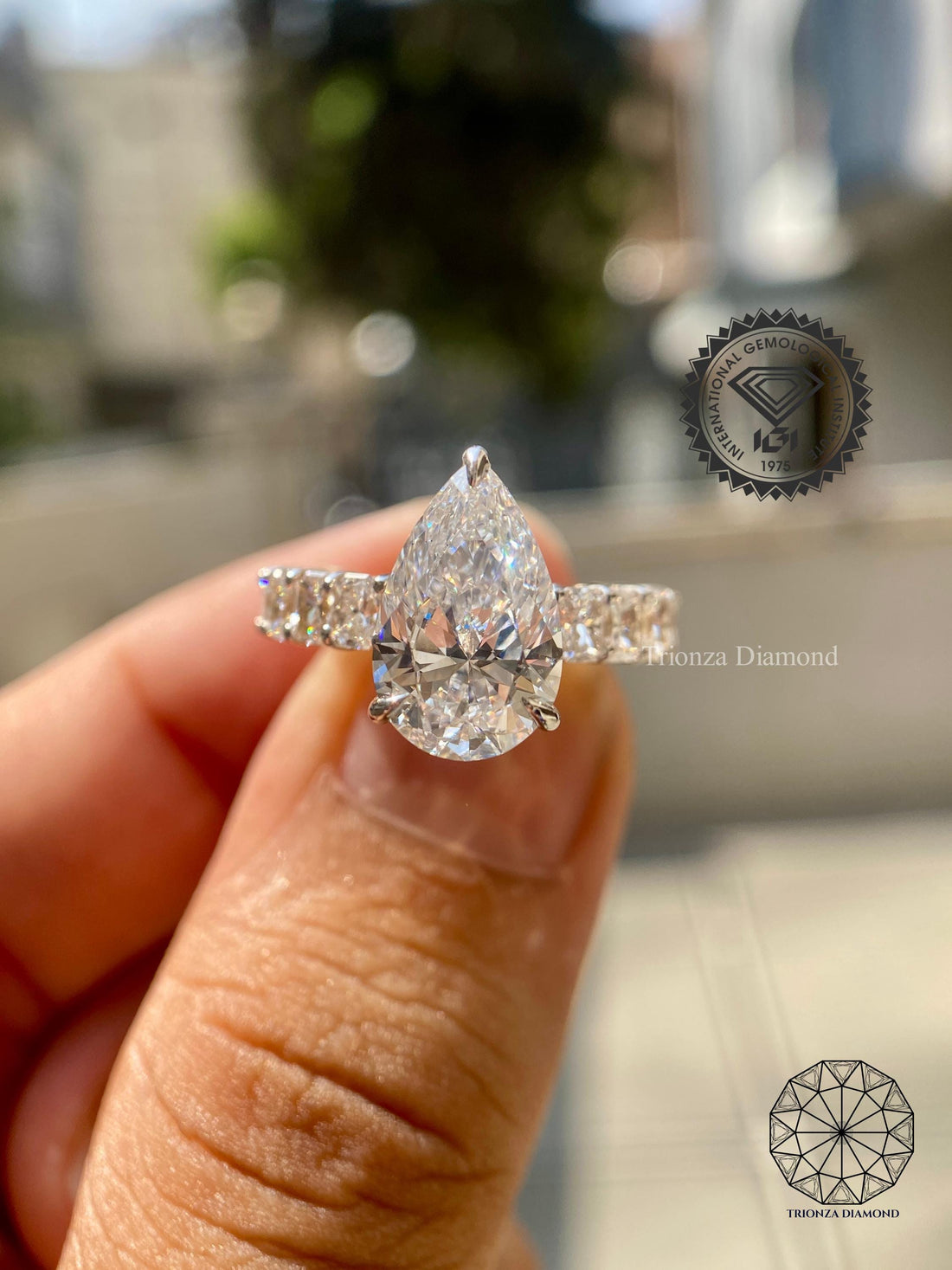 Pear cut lab grown diamond engagement ring paired with a radiant cut pave wedding band