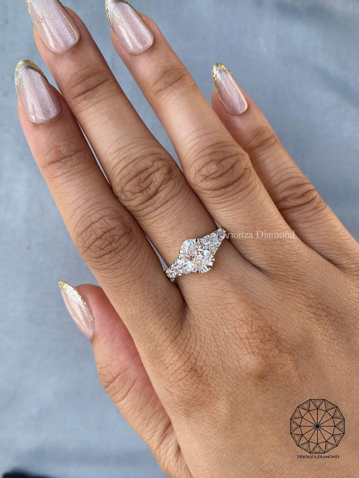 Woman wearing the oval cluster engagement ring for an everyday minimalist look