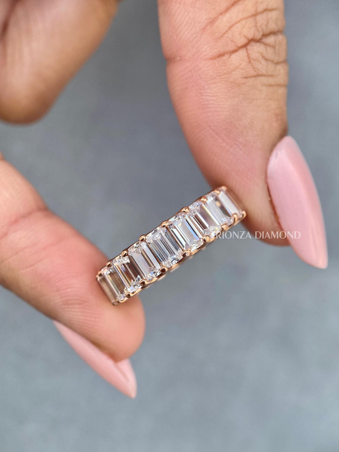Emerald cut lab grown diamond eternity band displayed with its rose gold U-prong setting