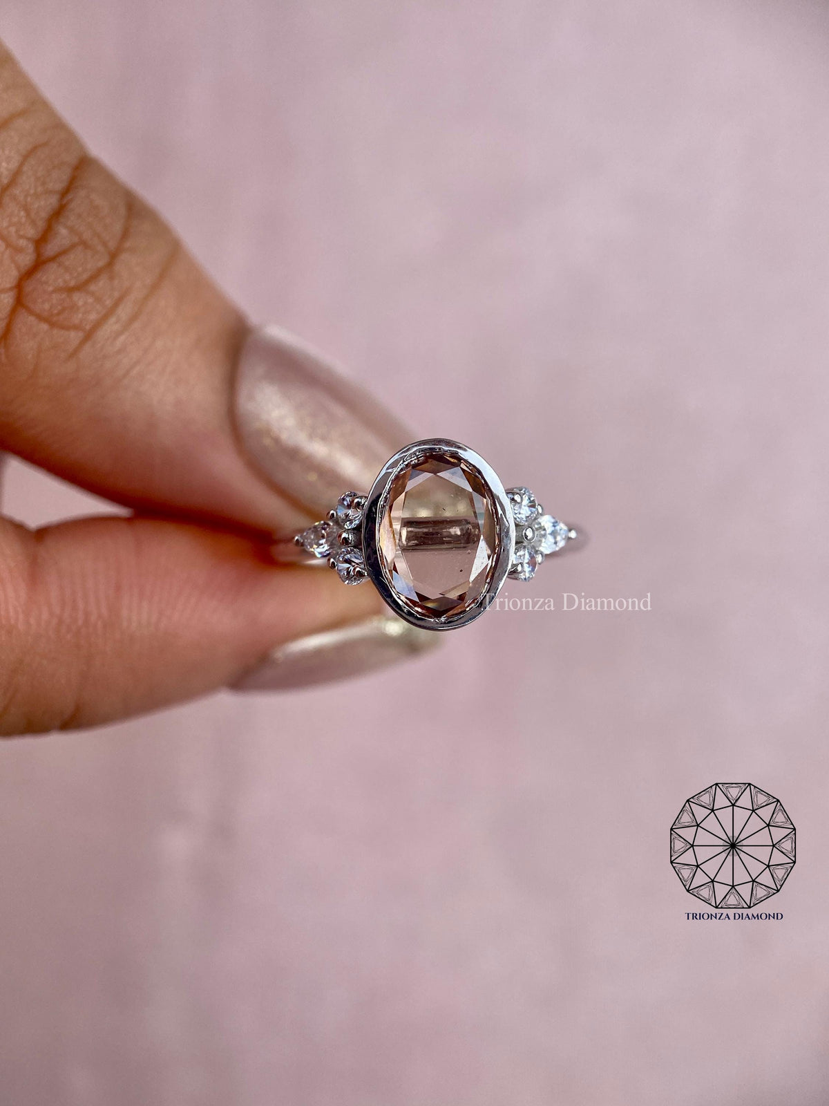 Bezel set diamond ring displayed to highlight the round and marquise accent stones