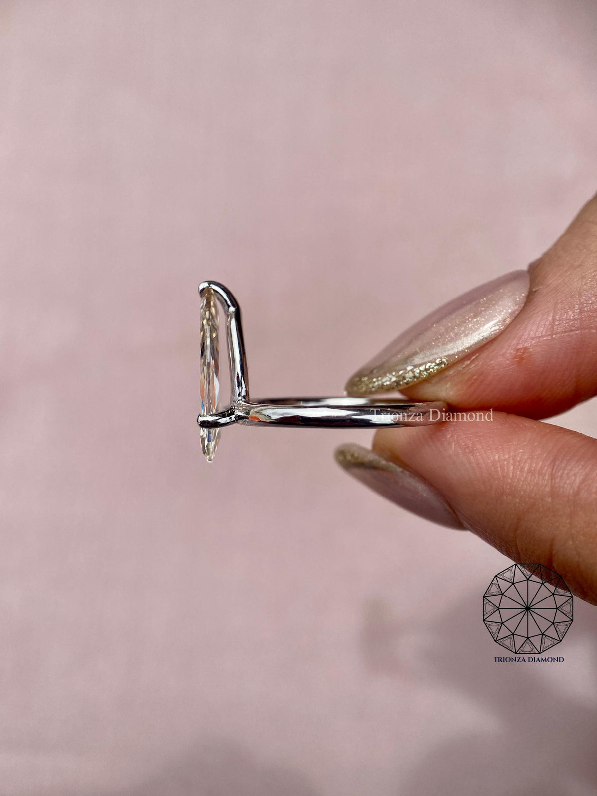 Side profile of the pear shaped diamond ring highlighting the open claw setting details