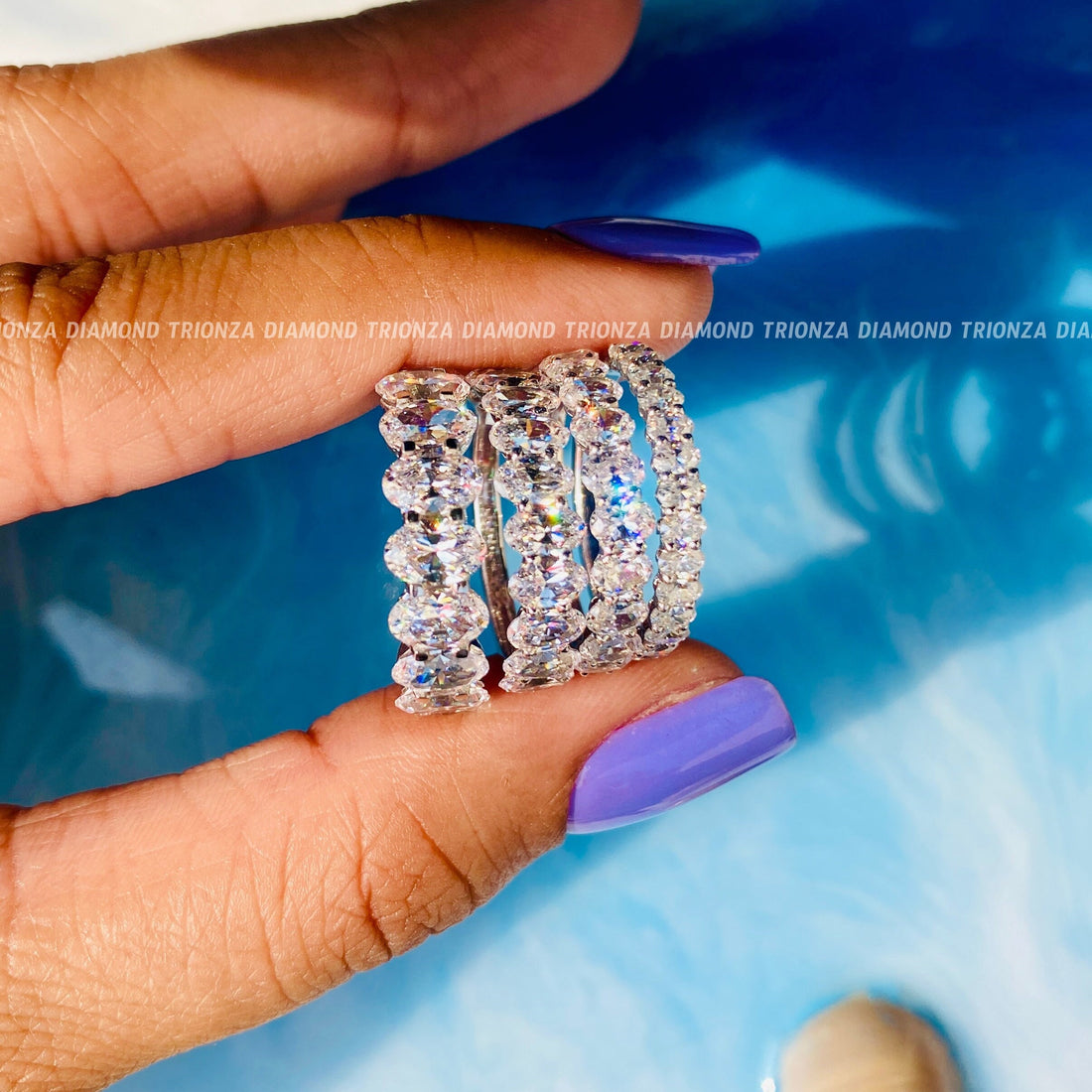 Oval cut lab grown diamond half eternity wedding band displayed in a ring box