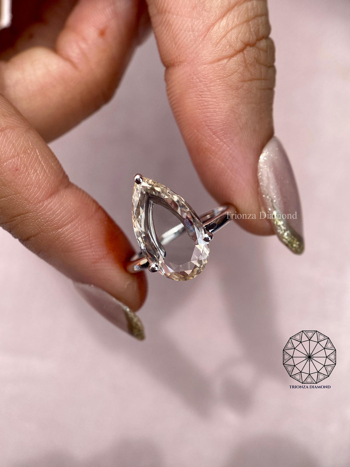 Woman wearing the pear cut diamond engagement ring, close-up view on her hand