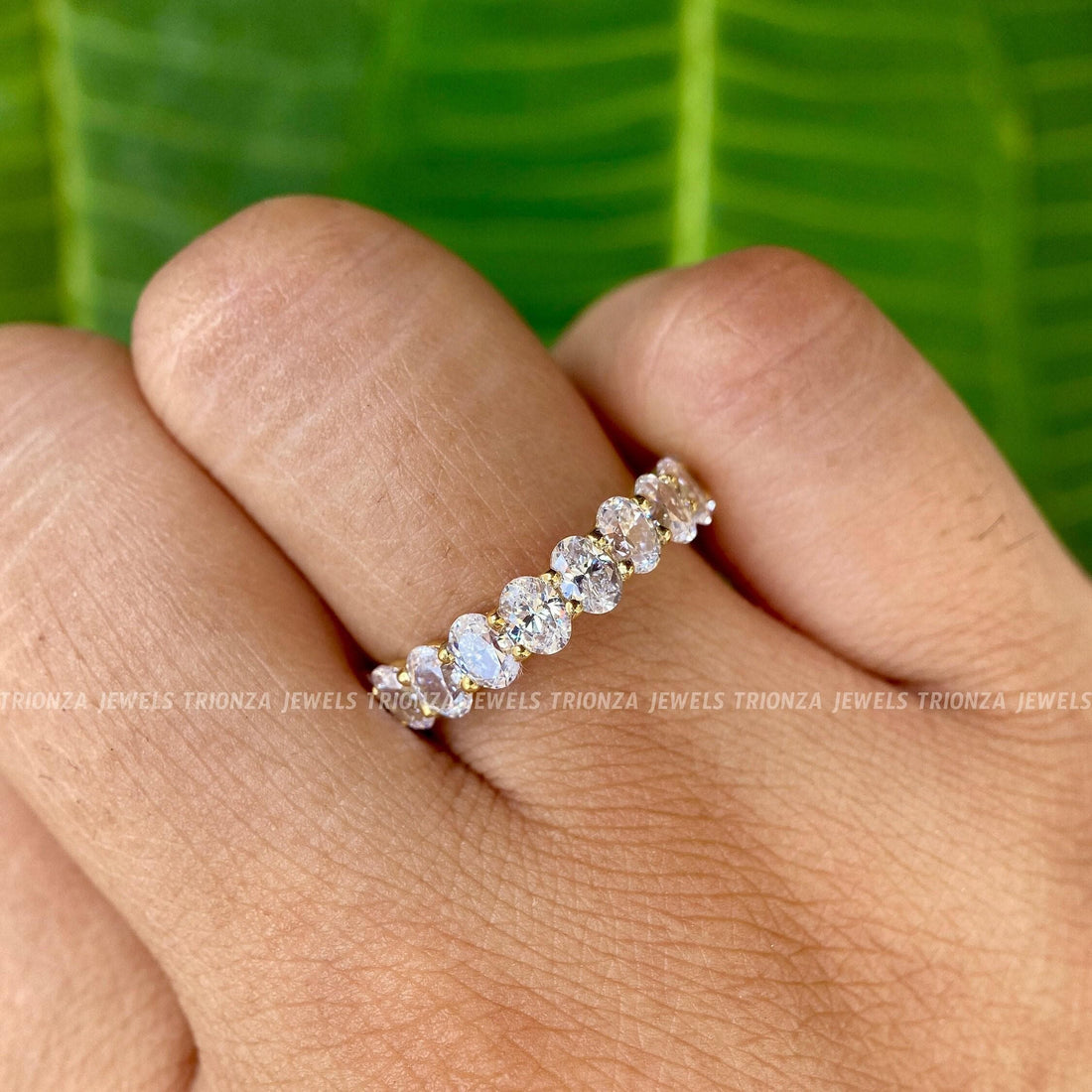 Oval moissanite half eternity band showcasing colorless VVS stones set in gold